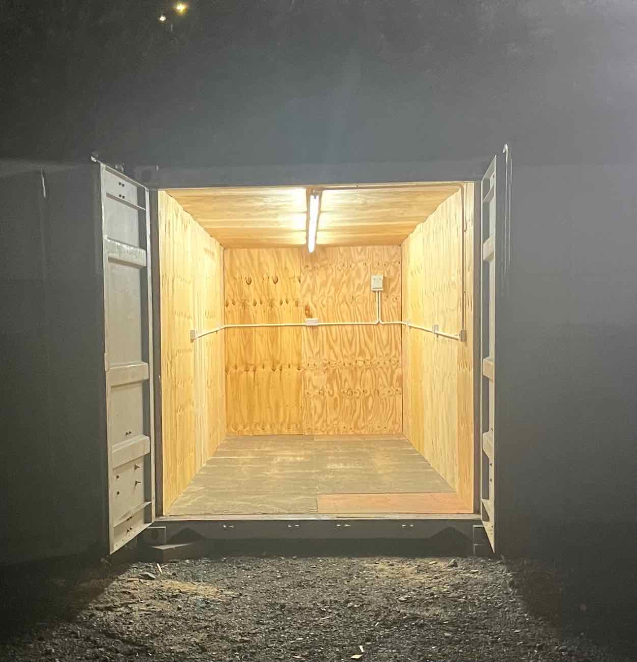 A GABA workshop unit at night, doors open, interior lit by a strip light